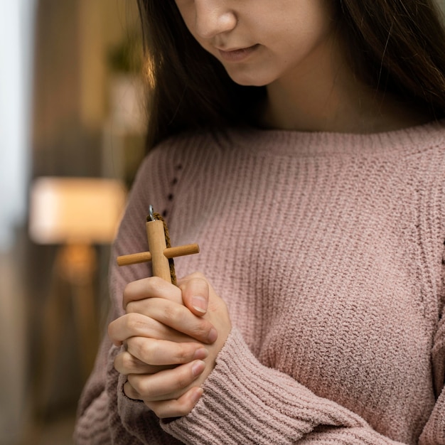 Kostenloses Foto frau, die mit holzkreuz betet