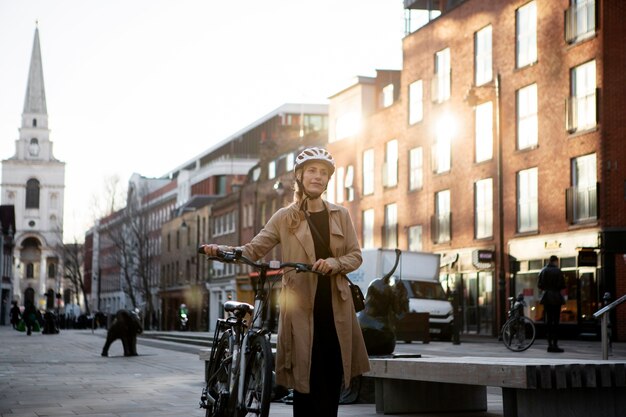 Frau, die mit ihrem Fahrrad in der Stadt spazieren geht