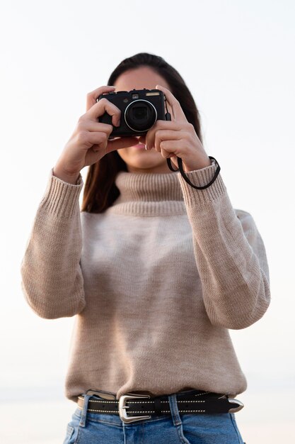 Kostenloses Foto frau, die mit kamera im freien fotografiert