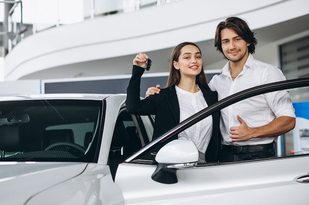 Frau, die mit männlicher seles Person in einem Autosalon spricht