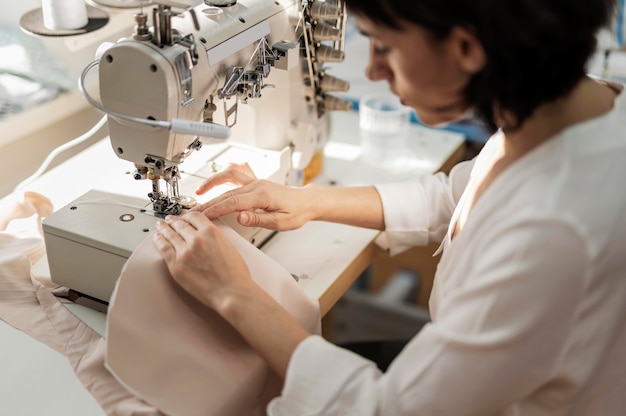 Kostenloses Foto frau, die mit nähmaschine arbeitet