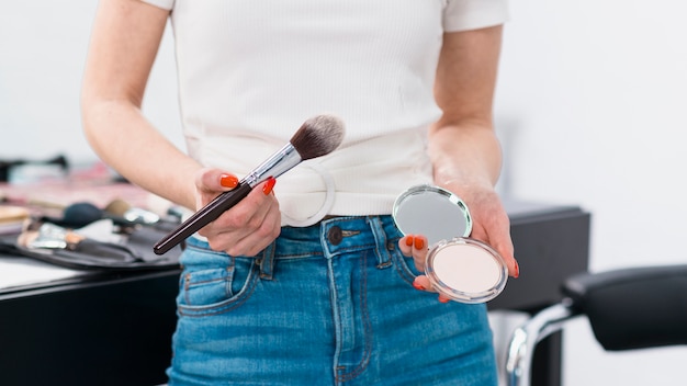 Kostenloses Foto frau, die mit pinsel und puder steht