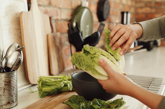 Frau, die mit Salat kocht