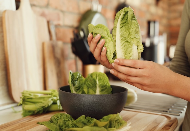 Frau, die mit Salat kocht