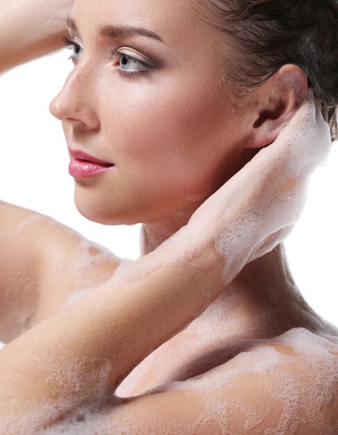 Frau, die mit Seife auf Körper und Kopf duscht. Hygiene- und Hautpflegekonzept