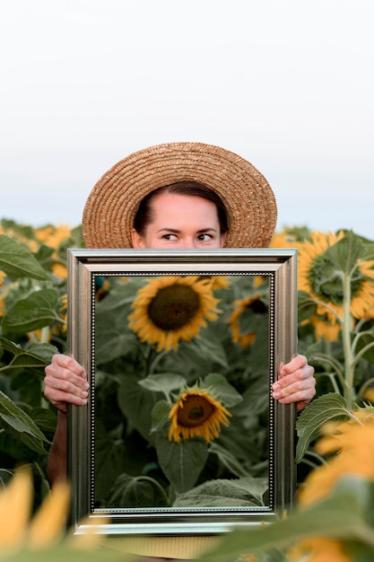 Kostenloses Foto frau, die mit spiegel im feld aufwirft