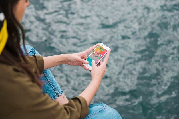 Frau, die Mobiltelefon mit Social Media-Benachrichtigungen auf Schirm verwendet