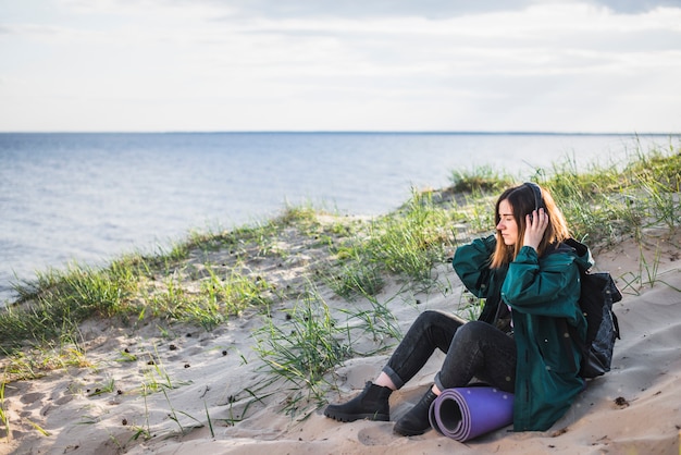 Frau, die Musik auf Strand hört