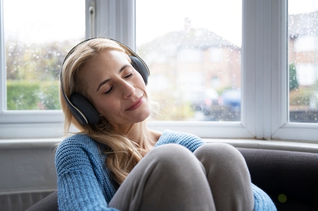 Frau, die Musik hört, während es regnet