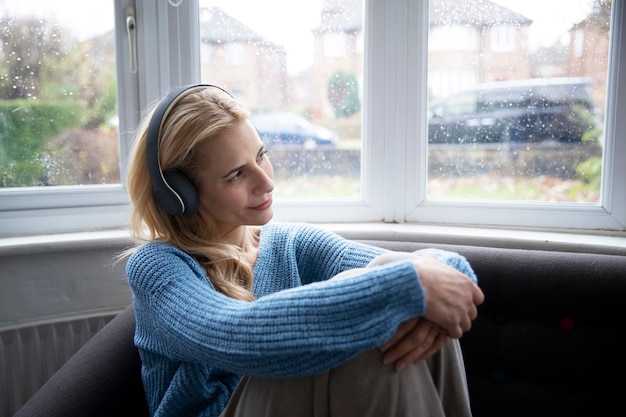 Frau, die Musik hört, während es regnet