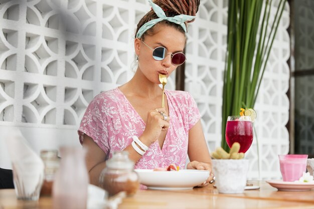 Frau, die Nachtisch und Getränk im Café genießt