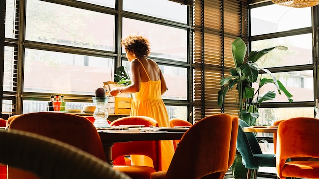 Frau, die nahe dem Fenster im Restaurant steht