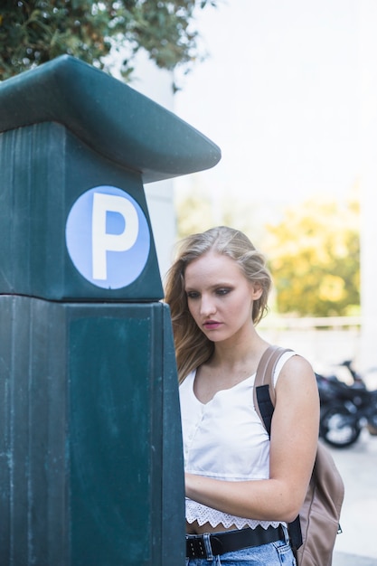 Kostenloses Foto frau, die nahe dem parkplatz an draußen steht