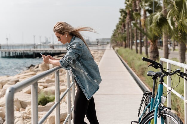 Frau, die neben ihrem Fahrrad steht