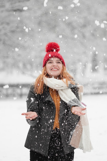 Kostenloses Foto frau, die oben schaut und im schnee steht