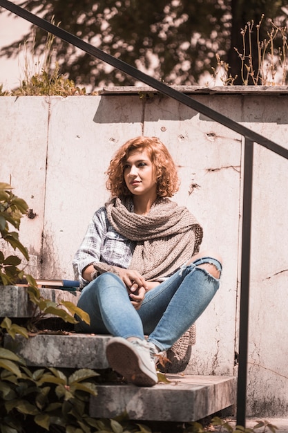 Frau, die öffentlich auf Garten der Schritte sitzt