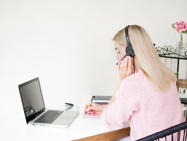 Frau, die online mit Kopfhörern lernt