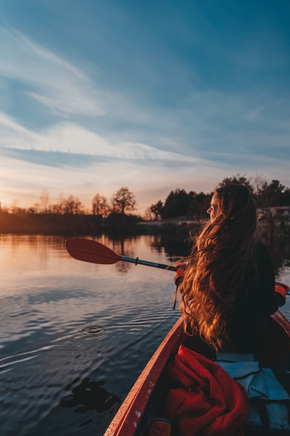 Frau, die Paddel in einem Kajak auf dem Fluss hält