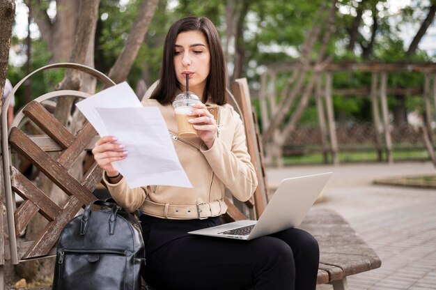 Frau, die Papiere hält und im Freien arbeitet