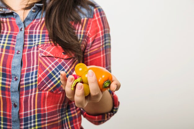 Frau, die Pfeffer und gelbe Kirschtomaten hält