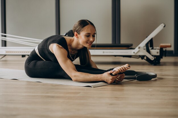 Frau, die Pilates auf dem Reformer ausübt