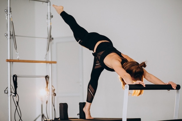 Frau, die pilates auf einem Reformer tut