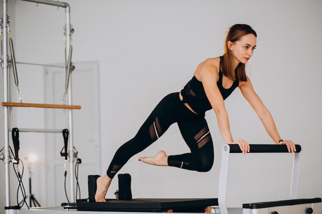 Frau, die pilates auf einem Reformer tut