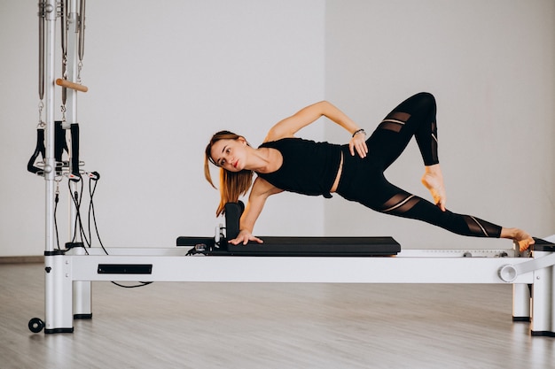 Frau, die pilates auf einem Reformer tut