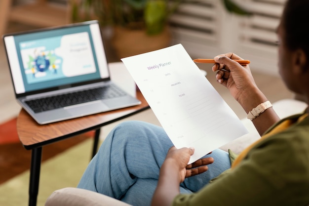 Frau, die Pläne macht, das Haus mit Laptop zu renovieren