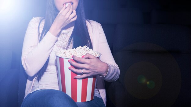 Frau, die Popcorn im Kino isst