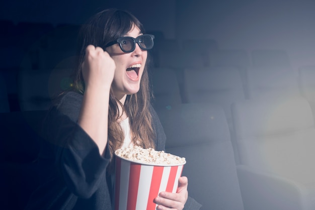 Frau, die Popcorn im Kino isst