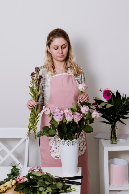 Frau, die Rosen für Bündel vorbereitet