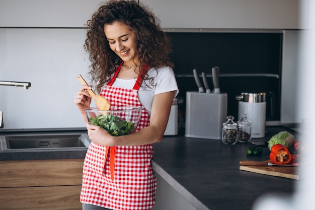 Kostenloses Foto frau, die salat an der küche macht