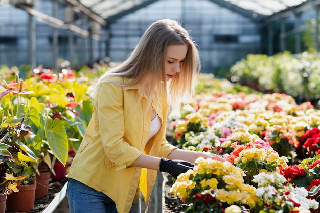 Kostenloses Foto frau, die schnörkelblumen sich interessiert