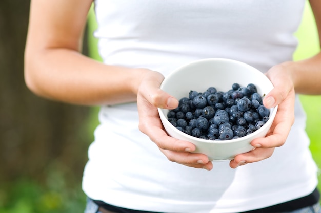 Frau, die Schüssel gefüllte Blaubeeren hält