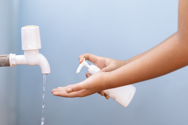 Frau, die Seife aus einer Handpressflasche in ihre Hand gießt
