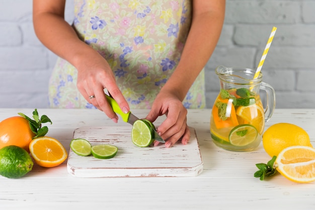 Frau, die selbst gemachte Limonade zubereitet