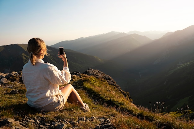 Frau, die selfie auf Bergseitenansicht nimmt