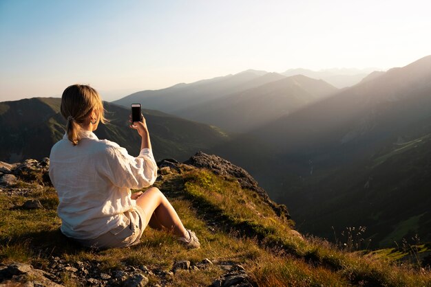 Frau, die selfie auf Bergseitenansicht nimmt