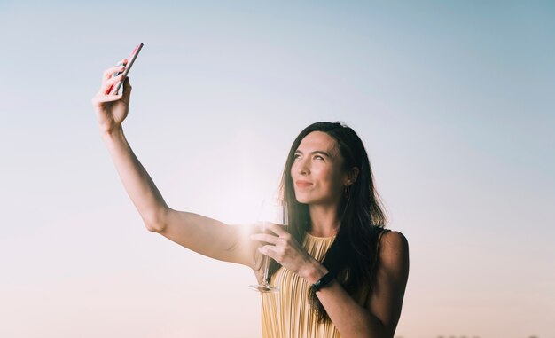 Frau, die selfie im Sonnenlicht nimmt