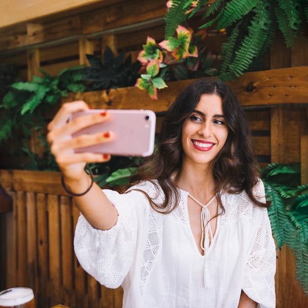 Frau, die selfie mit rosa smartphone nimmt