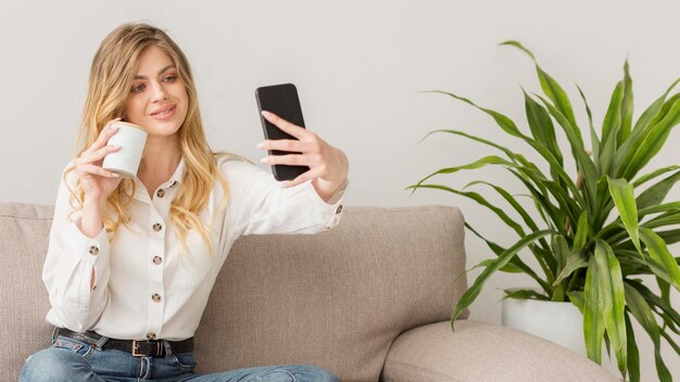 Frau, die selfie mit Telefon nimmt