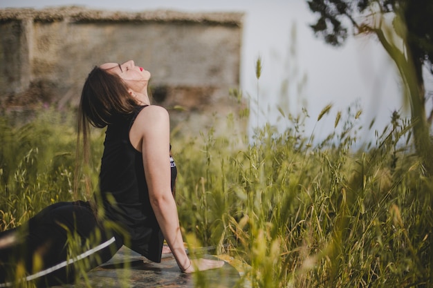 Kostenloses Foto frau, die sich auf dem feld ausdehnt