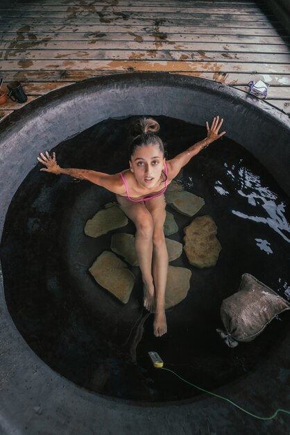 Frau, die sich in einem runden Bad im Freien entspannt, Bio-Hautpflege in einem heißen Bad