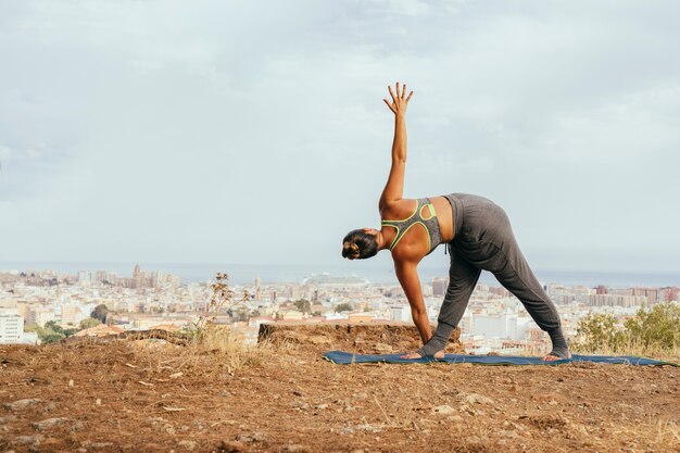 Frau, die sich mit Yoga-Übungen ausdehnt