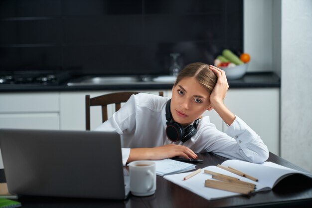 Frau, die sich nach Fernarbeit am Laptop erschöpft fühlt