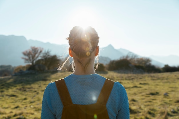 Frau, die Sonne in der Natur gegenüberstellt