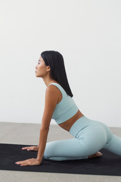 Frau, die Sport auf Yogamatte praktiziert
