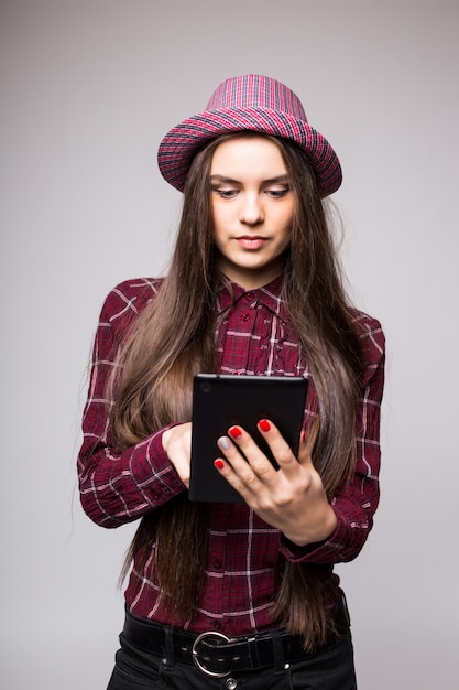 Frau, die Tablet-Computer lokalisiert auf weißer Wand hält. Arbeiten am Touchscreen. Lässige lächelnde kaukasische asiatische Frau.