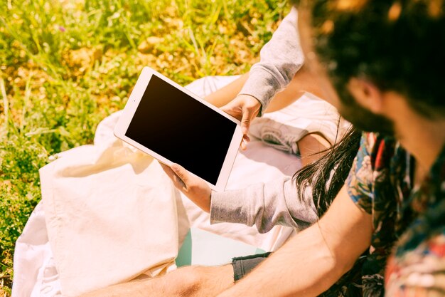 Frau, die Tablette in der Wiese hält